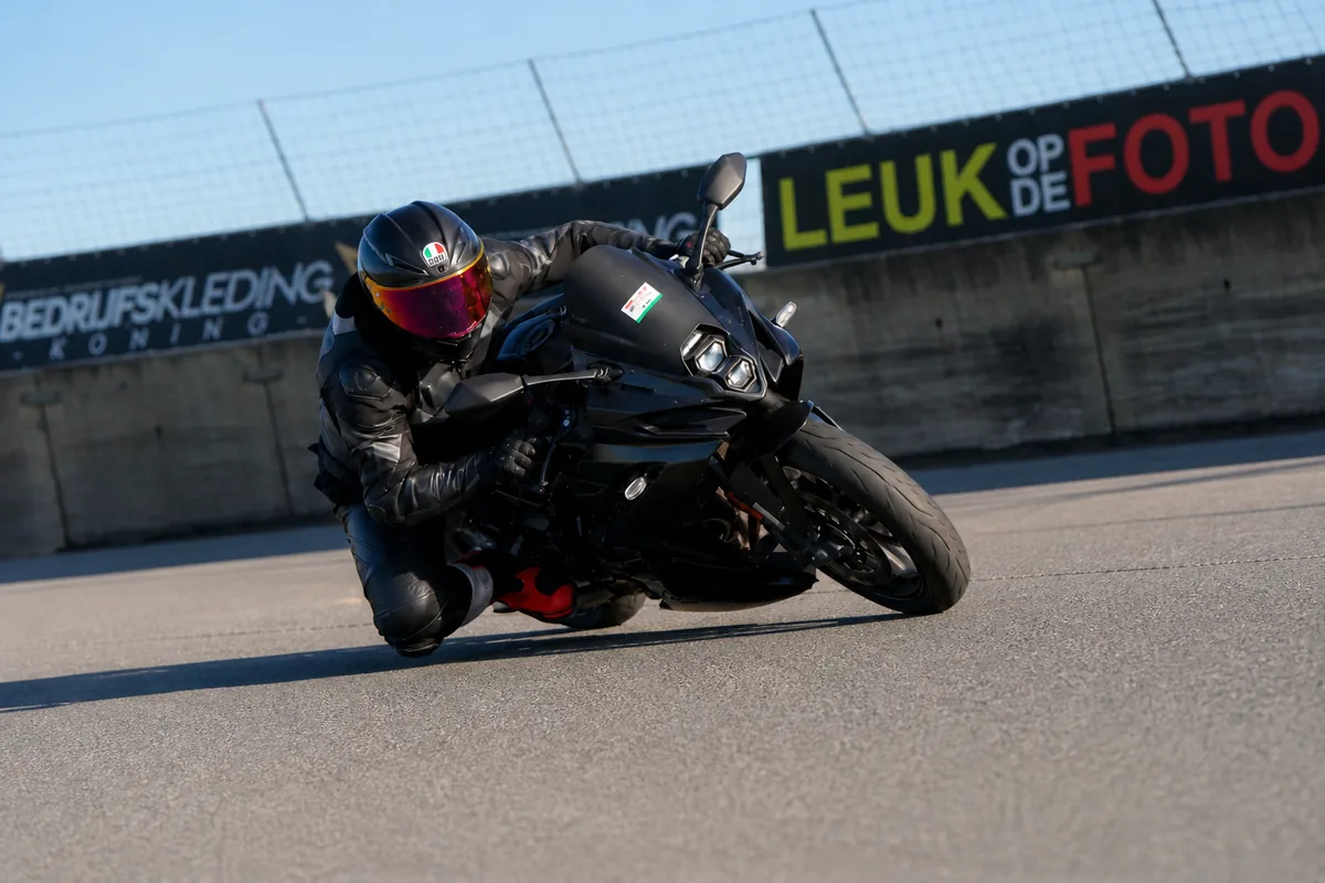 Mickey op een motorfiets op het circuit
